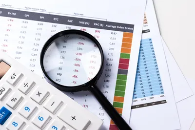 Work-with-magnifying-glass-calculator-papers